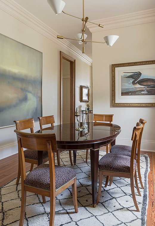 Because the leopard print appears only on the seats of the dining chairs, and in a muted colorway, it plays a supporting role to the more prominent pattern of the Beni Ourain rug and the bold art. Photo by Sara Essex Bradley, courtesy of Graci Interiors.
